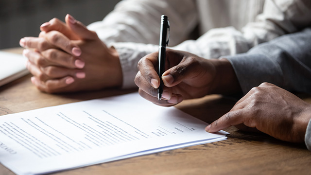 Close up view of mediator and client writing settlement agreement
